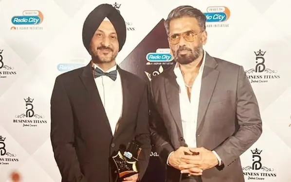 Dr Sandeep Anand holding the Business Titans trophy